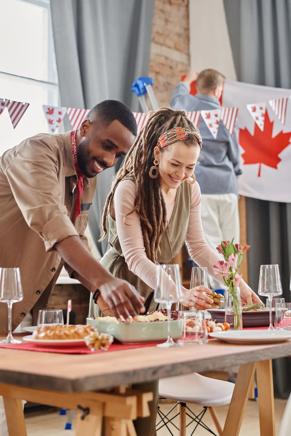 A smiling man and woman preparing a Canada Day celebration